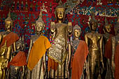 Wat Xieng Thong temple in Luang Prabang, Laos. standing Buddha statues in the  calling for rain  mudra with both arms down at sides and palms against thighs. Royal Funerary carriage hall. 